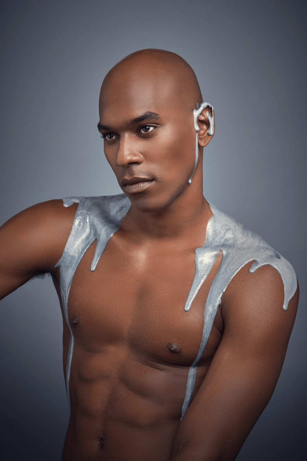 Streams of silver flowing across the body, creating a futuristic and sculptural look where makeup meets art.